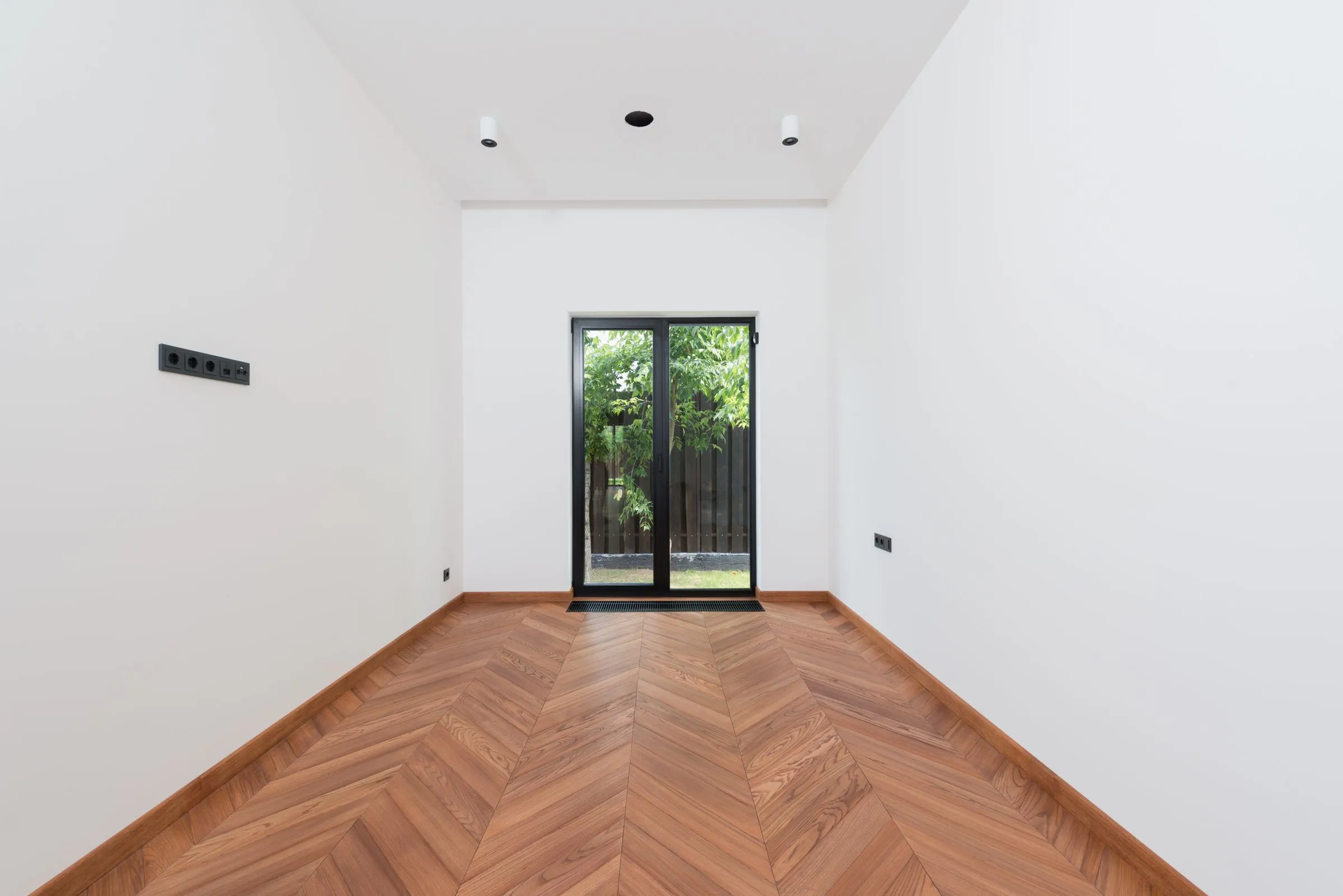 Herringbone parquet leading to a garden door in a Berlin Altbau