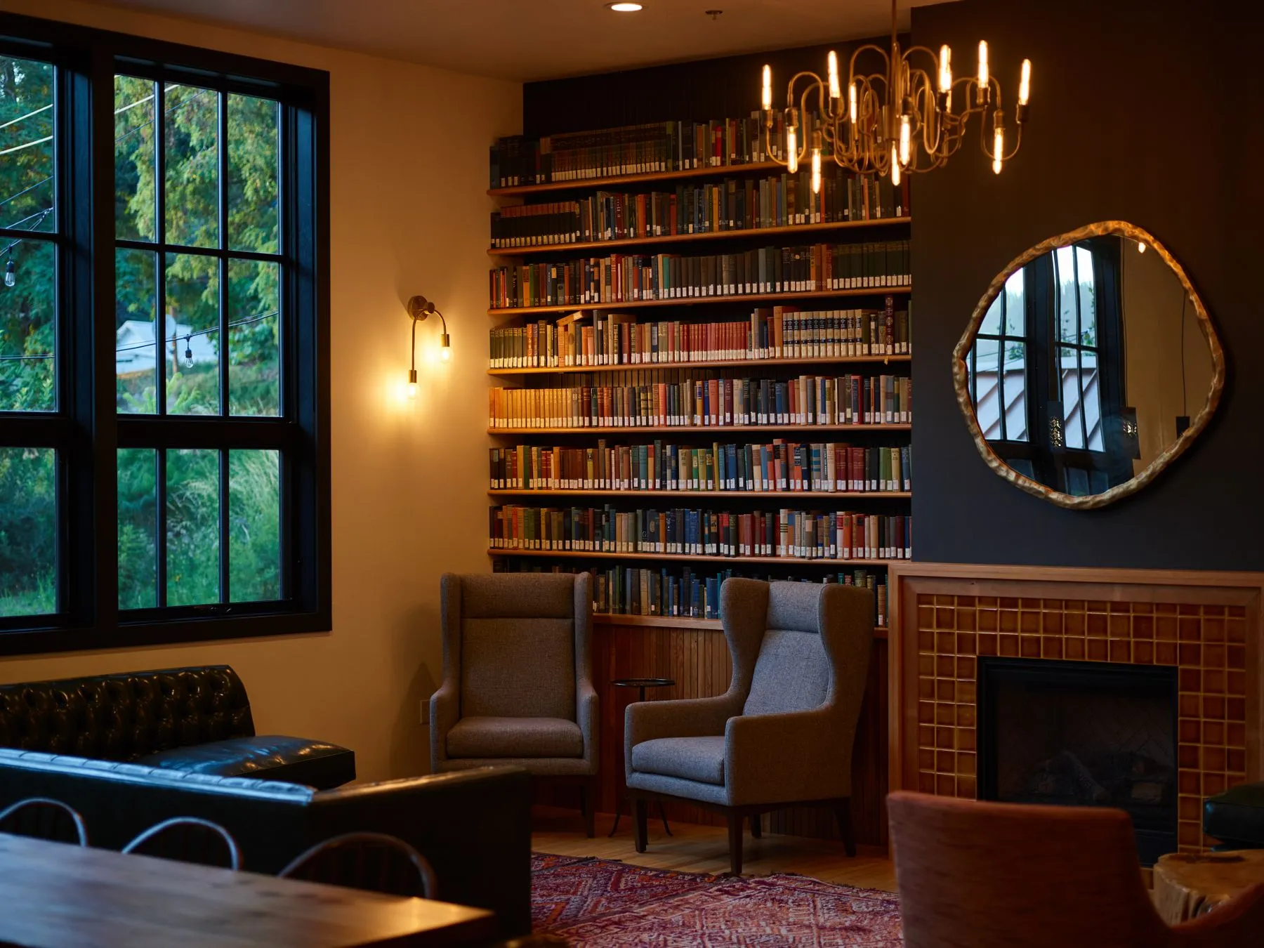 A warm home library with a full-height wall of books